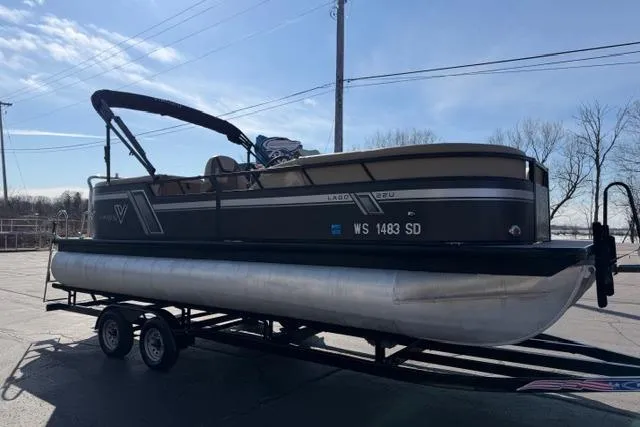 Slide: The Image of 2022 Viaggio Lago 22U pontoon boat on trailer, parked outdoors under clear sky. - 4