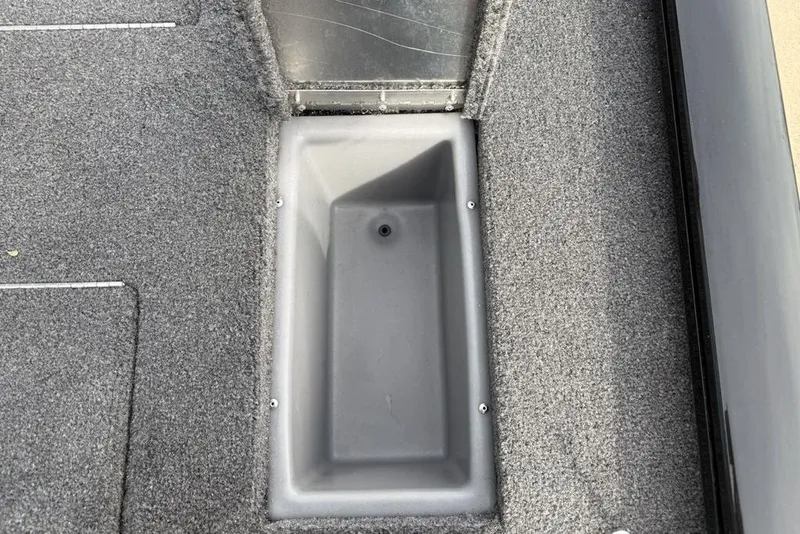 Slide: The Image of 2018 Tracker Pro Team 175 TXW boat interior with gray carpet and storage compartment. - 24