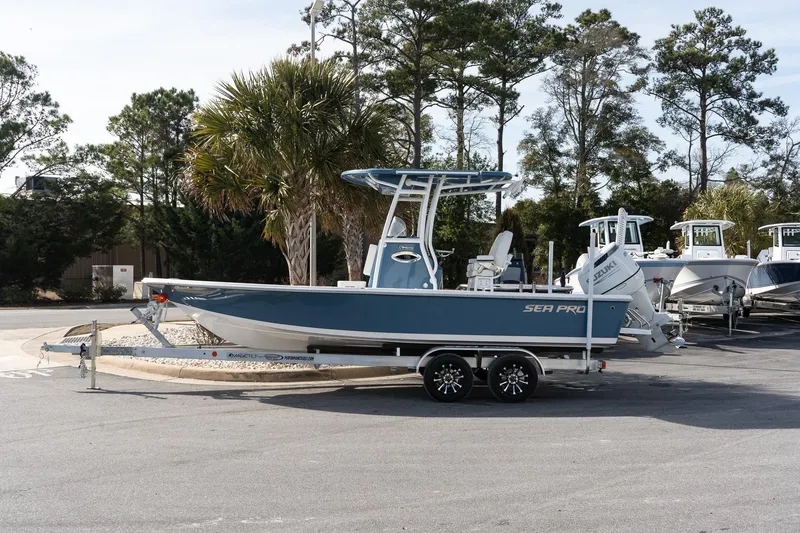 The Image of 2026 Sea Pro 230 Bay boat on trailer, parked outdoors with trees in background. - 1