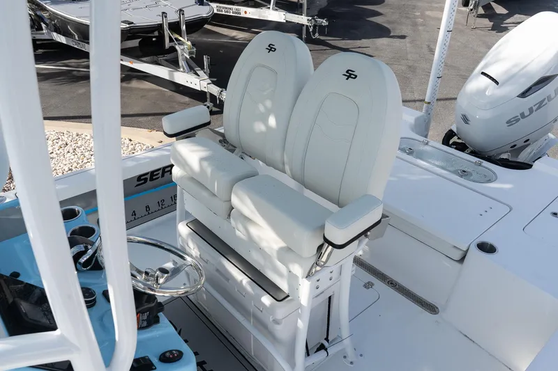 Slide: The Image of 2026 Sea Pro 250 Bay boat interior with dual white seats and Suzuki outboard motor. - 13