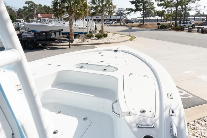 Slide: The Image of 2026 Sea Pro 250 Bay boat on display at a marina with palm trees. - 16