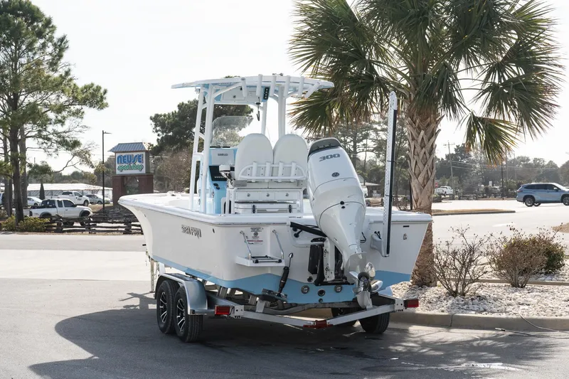 Slide: The Image of 2026 Sea Pro 250 Bay boat on trailer, parked near palm tree in sunny setting. - 3