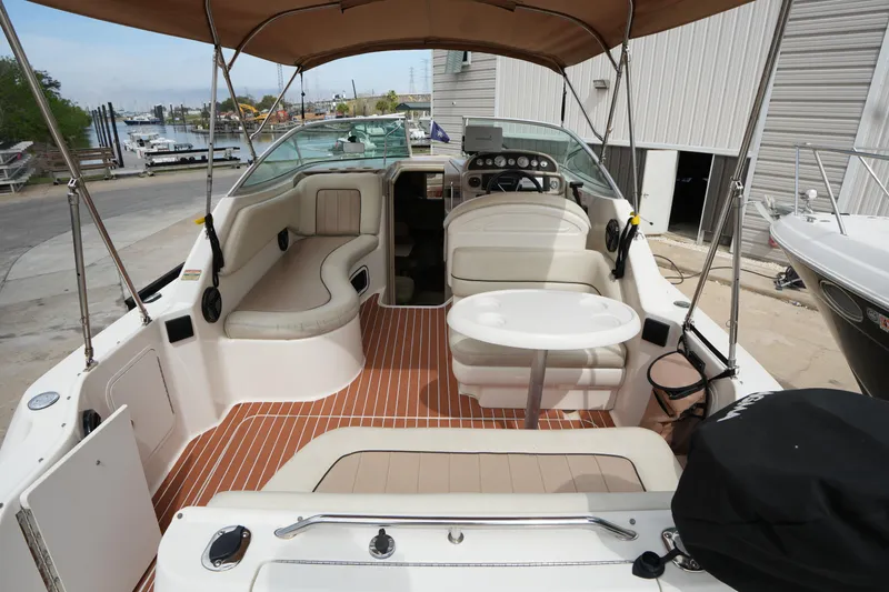 Slide: The Image of 2000 Sea Ray 270 Sundancer boat interior with seating and table, docked at marina. - 12