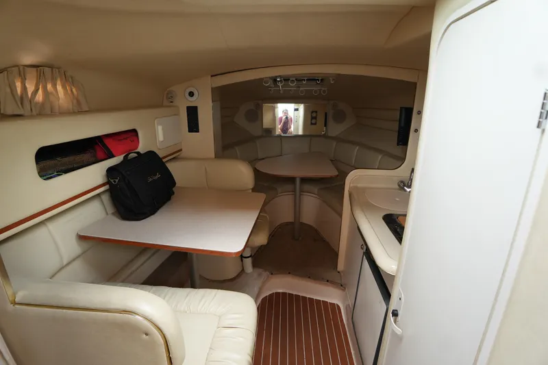 Slide: The Image of Interior of 2000 Sea Ray 270 Sundancer boat with seating, table, and kitchenette. - 16
