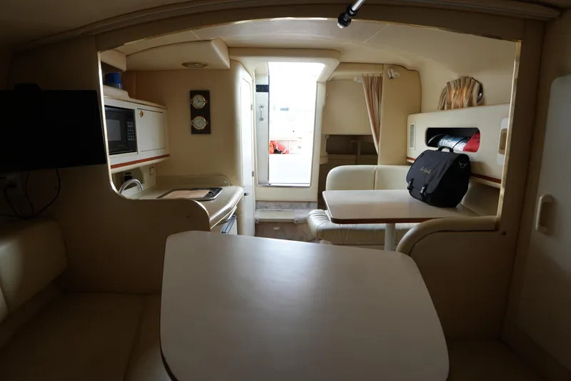 Slide: The Image of Interior of 2000 Sea Ray 270 Sundancer boat with kitchenette and seating area. - 19