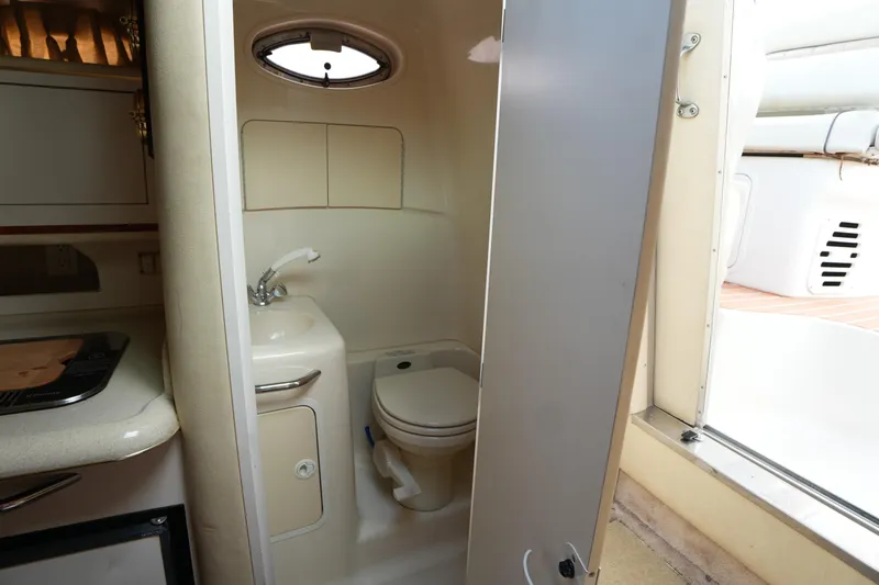 Slide: The Image of 2000 Sea Ray 270 Sundancer boat bathroom interior with sink and toilet. - 22