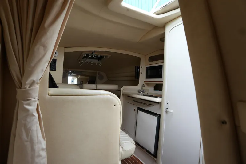 Slide: The Image of Interior of 2000 Sea Ray 270 Sundancer boat, featuring kitchenette and seating area. - 25