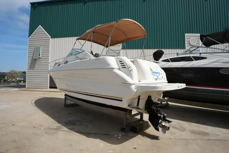 Slide: The Image of 2000 Sea Ray 270 Sundancer boat with canopy, displayed outdoors on a stand. - 3