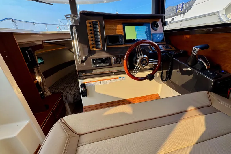 Slide: The Image of 2024 Ranger Tugs R-27 helm with navigation controls and cozy cabin interior. - 11