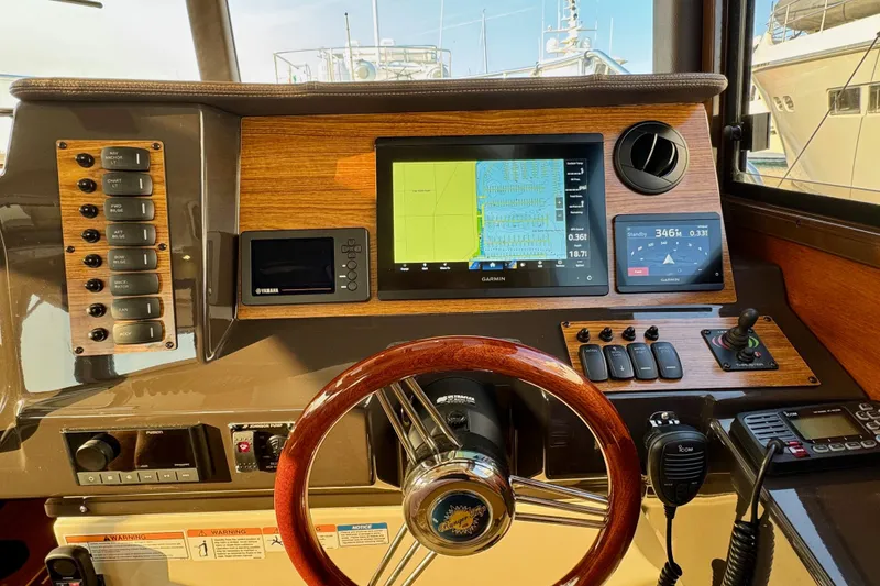 Slide: The Image of 2024 Ranger Tugs R-27 helm with navigation screens and controls. - 12