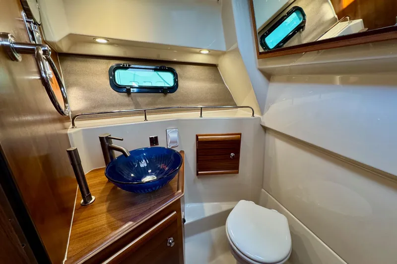 Slide: The Image of Luxurious 2024 Ranger Tugs R-27 bathroom with modern sink and elegant wood accents. - 16