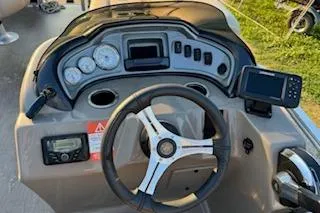 Slide: The Image of 2023 Sun Tracker Fishin' Barge 20 DLX dashboard with steering wheel and gauges. - 16