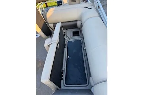Slide: The Image of 2023 Sun Tracker Fishin' Barge 20 DLX with open storage compartment and beige seating. - 18
