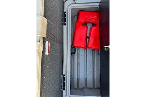 Slide: The Image of 2023 Sun Tracker Fishin' Barge 20 DLX storage compartment with red life jacket. - 19
