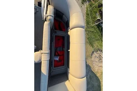 Slide: The Image of 2023 Sun Tracker Fishin' Barge 20 DLX with open storage compartment and beige seating. - 9