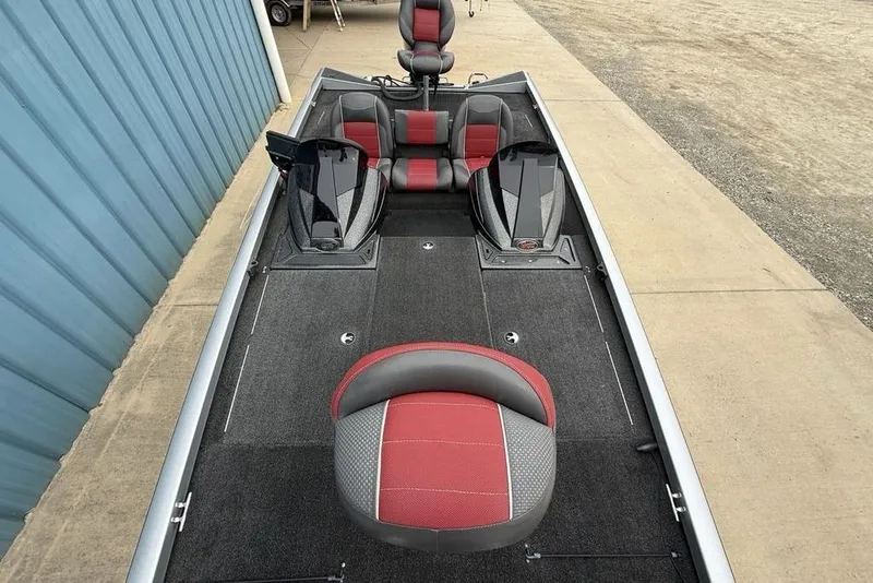 Slide: The Image of 2017 Ranger RT188 boat interior with red and gray seating, parked by a blue building. - 28
