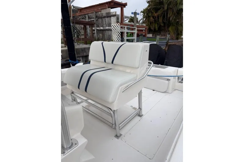 Slide: The Image of 2008 SeaVee 320B boat with white seating and blue accents, docked outdoors. - 11