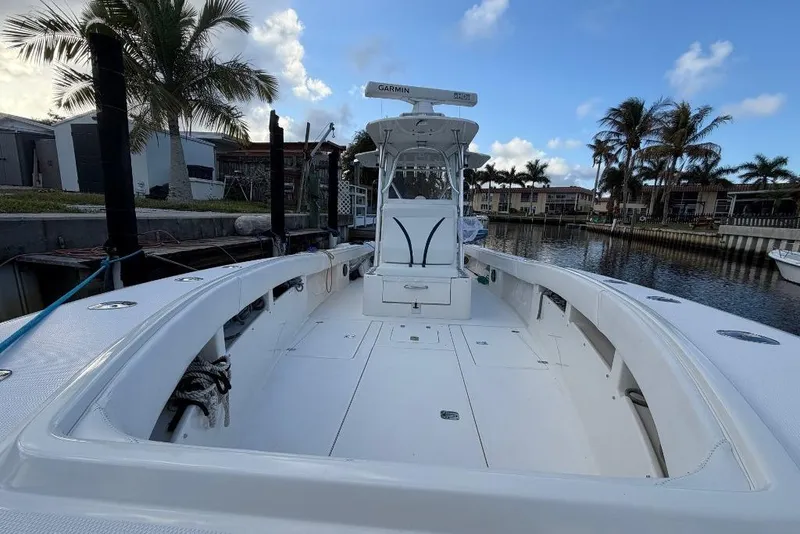 Slide: The Image of 2008 SeaVee 320B boat docked, featuring spacious deck and palm trees in the background. - 14