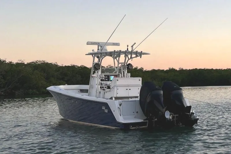 Slide: The Image of 2008 SeaVee 320B boat with dual engines on calm water at sunset. - 4