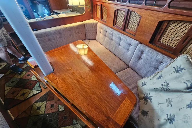 Slide: The Image of Cozy interior of 1990 Ericson 34 sailboat with wooden table and cushioned seating. - 10