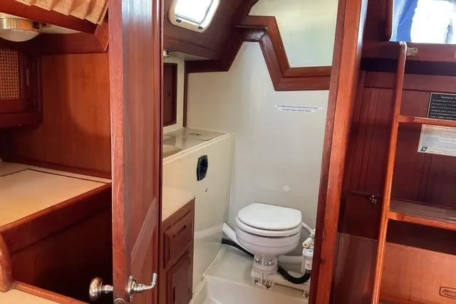 Slide: The Image of 1990 Ericson 34 yacht interior with wooden cabinetry and compact bathroom. - 20