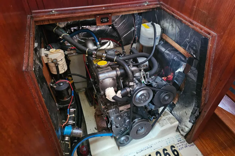 Slide: The Image of Engine compartment of a 1990 Ericson 34 sailboat, showcasing mechanical components and wiring. - 22