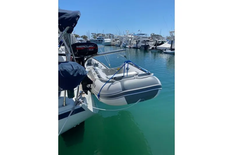 Slide: The Image of Ericson 34 sailboat with inflatable dinghy and Mercury outboard motor in marina, 1990 model. - 3