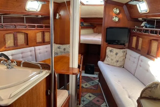 Slide: The Image of Interior of a 1990 Ericson 34 sailboat with cozy seating and wooden finishes. - 9