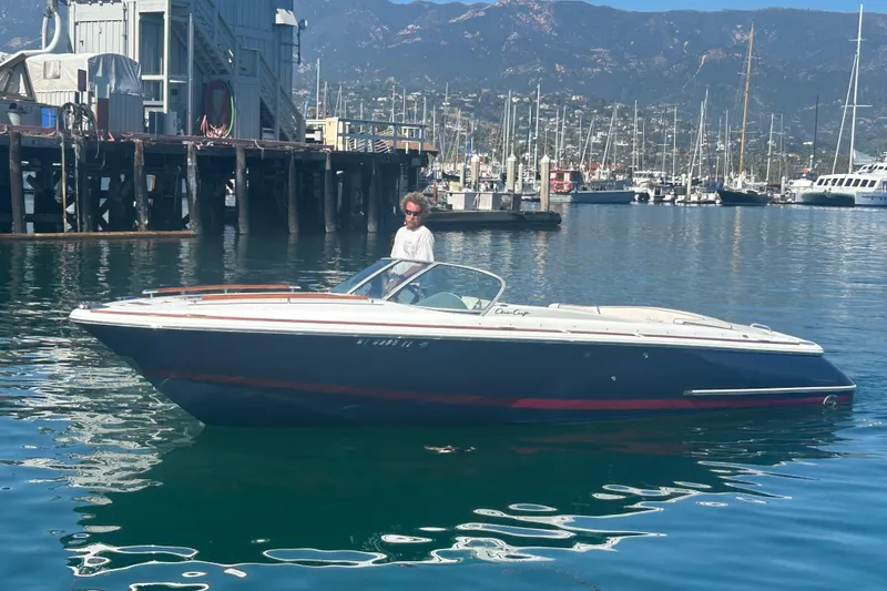 The Image of 2004 Chris-Craft Corsair 25 boat docked in a scenic marina setting. - 0