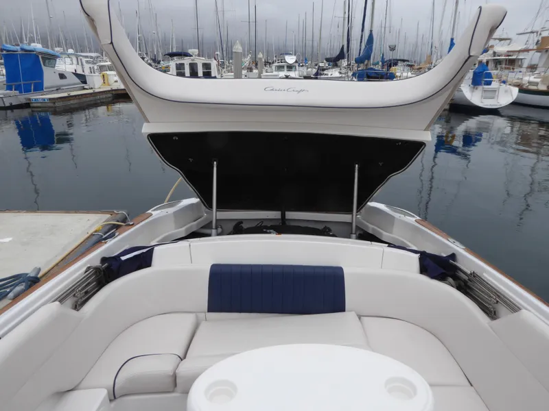 Slide: The Image of 2004 Chris-Craft Corsair 25 boat in harbor with open storage compartment. - 14