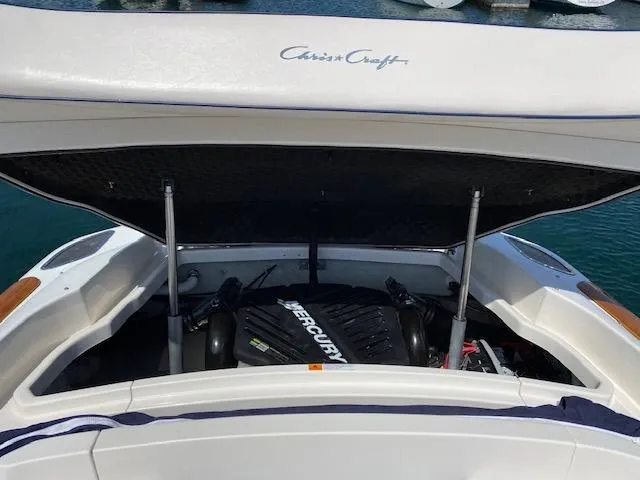 Slide: The Image of 2004 Chris-Craft Corsair 25 with open engine compartment by the water. - 15