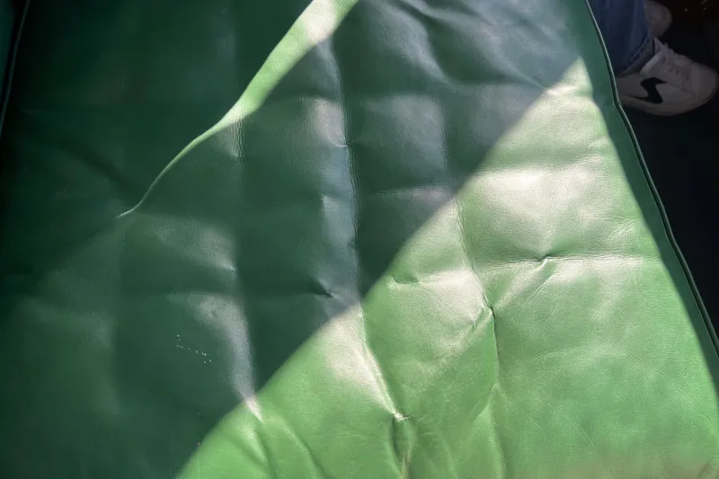 Slide: The Image of Green leather seat of 1948 Chris-Craft 24 Sportsman boat, partially sunlit. - 11