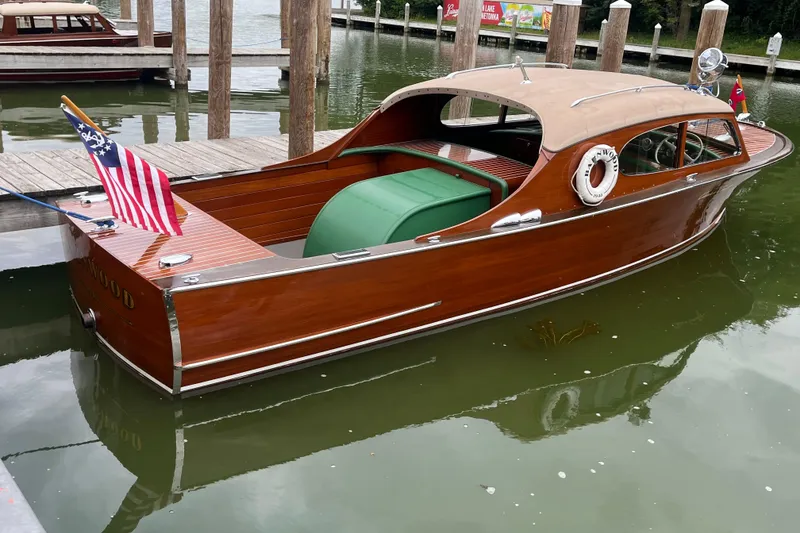 Slide: The Image of 1948 Chris-Craft 24 Sportsman wooden boat docked, featuring classic design and American flag. - 3