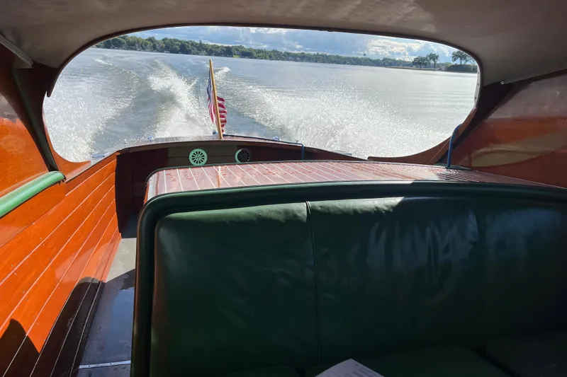 Slide: The Image of 1948 Chris-Craft 24 Sportsman boat cruising on a lake, showcasing wooden interior and American flag. - 8