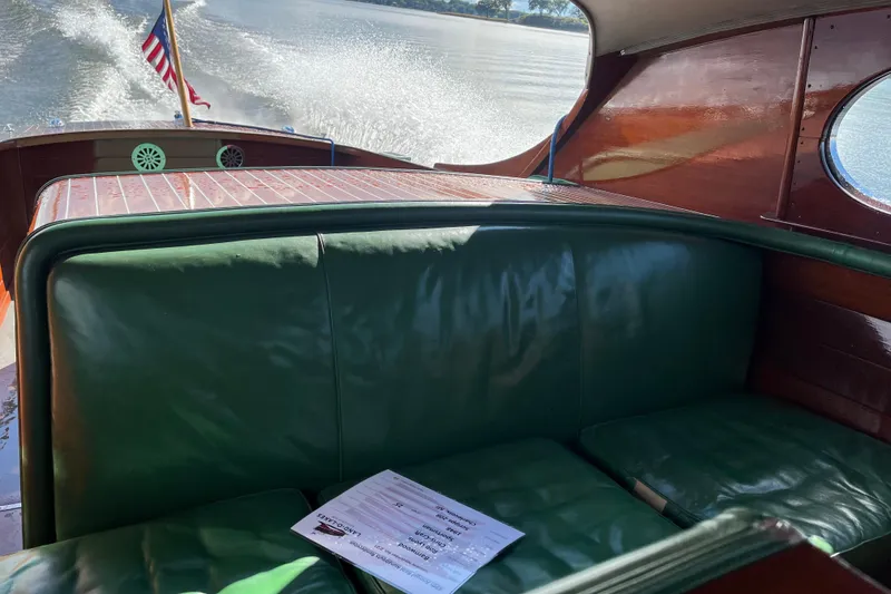 Slide: The Image of 1948 Chris-Craft 24 Sportsman boat interior with green seating and American flag. - 9