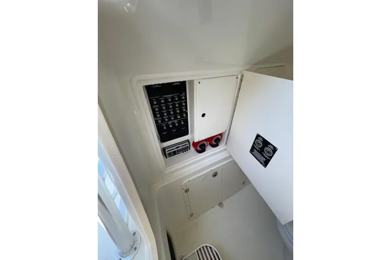 Slide: The Image of 2008 Boston Whaler 320 Outrage electrical panel and controls in cabin interior. - 18