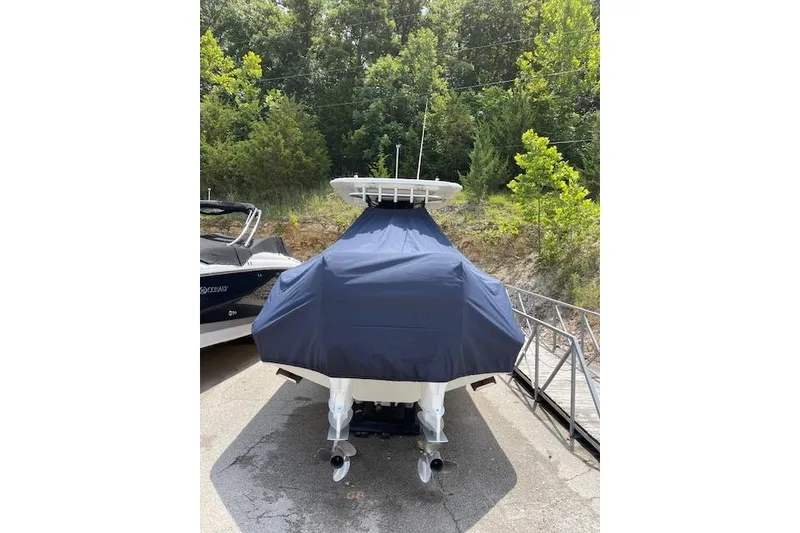 Slide: The Image of 2008 Boston Whaler 320 Outrage boat covered, parked near a wooded area. - 22