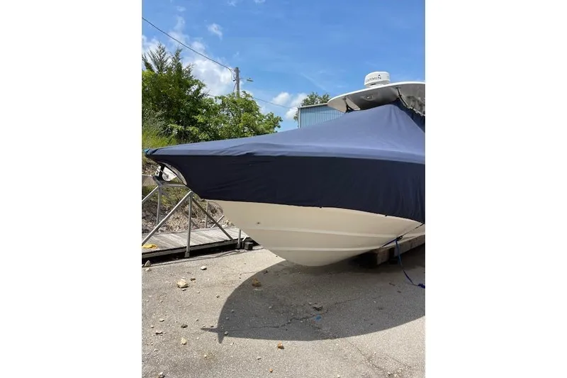 Slide: The Image of 2008 Boston Whaler 320 Outrage boat with cover, parked outdoors. - 23