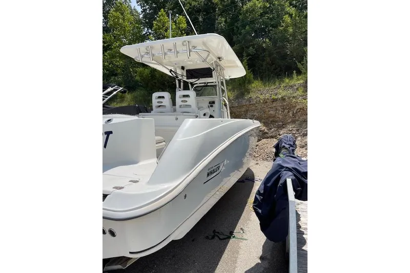 Slide: The Image of 2008 Boston Whaler 320 Outrage boat docked, featuring sleek design and spacious seating. - 5