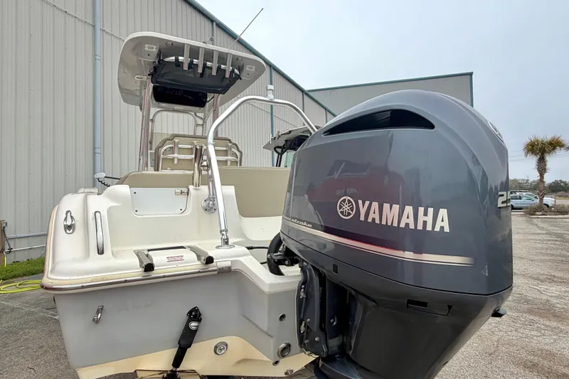 Slide: The Image of 2021 Key West 239 FS boat with Yamaha outboard motor, docked near a warehouse. - 13