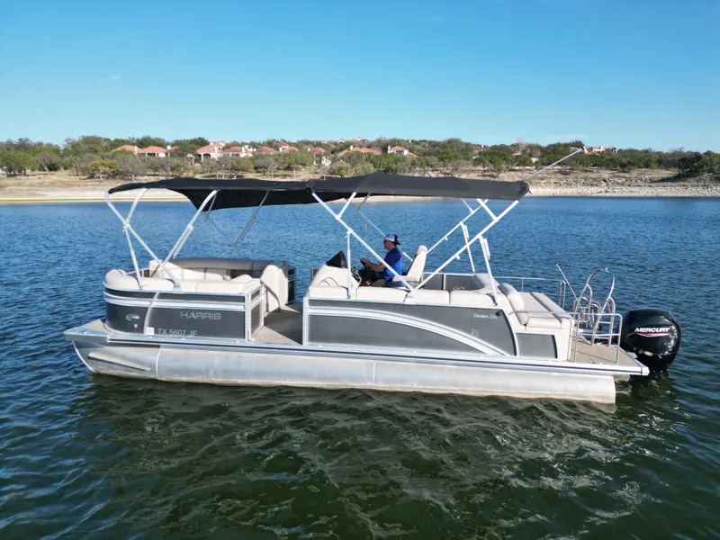 The Image of 2021 Harris FloteBote 250CR pontoon boat on a calm lake. - 0