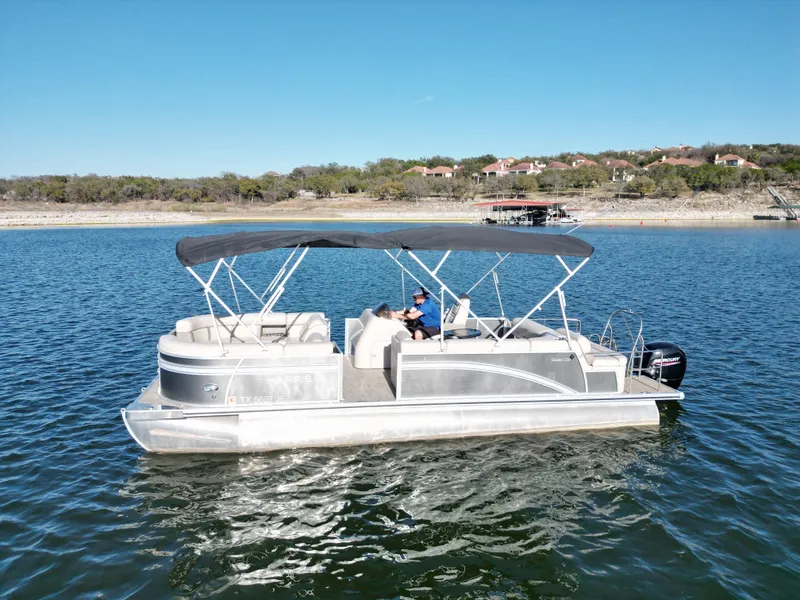 Slide: The Image of 2021 Harris FloteBote 250CR pontoon boat on a serene lake. - 19