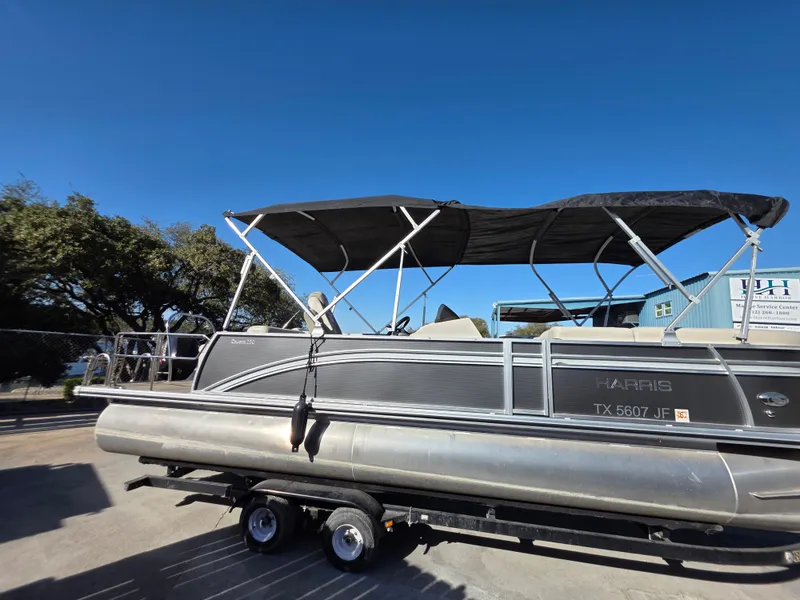 Slide: The Image of Harris FloteBote 250CR 2021 pontoon boat with black canopy on trailer. - 8