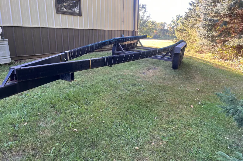 Slide: The Image of Black boat trailer on grass, near a building, for 1958 Chris-Craft 31 Sedan Cruiser. - 23