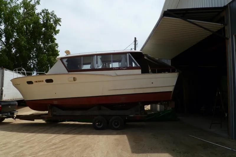 Slide: The Image of 1958 Chris-Craft 31 Sedan Cruiser on trailer near a garage, side view. - 3