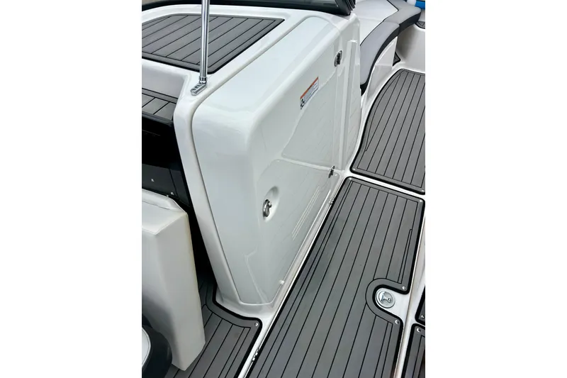 Slide: The Image of 2018 Yamaha Boats 242X interior with sleek, modern deck design and storage compartment. - 27