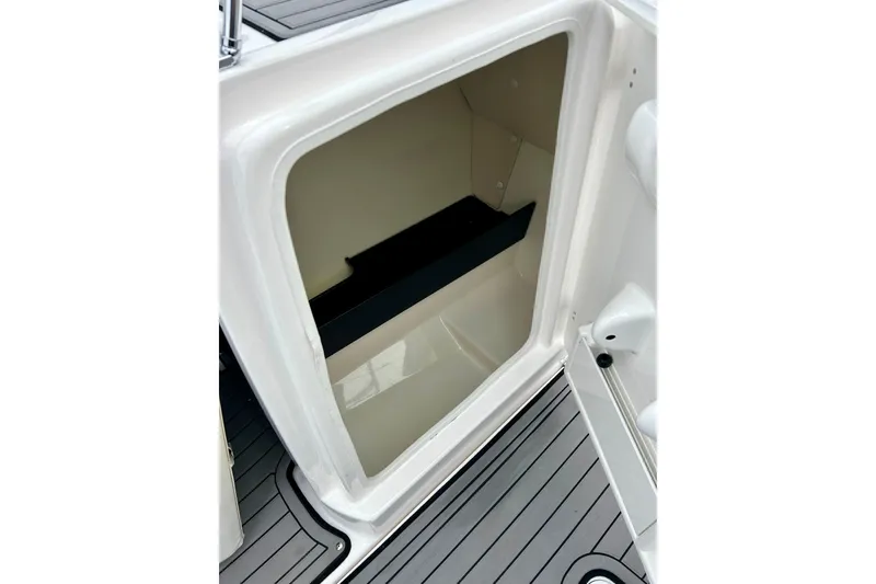 Slide: The Image of Open storage compartment on 2018 Yamaha Boats 242X, featuring sleek interior design. - 28