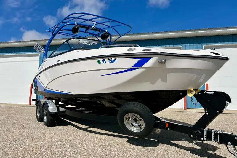 Slide: The Image of 2018 Yamaha Boats 242X on trailer, parked outdoors under blue sky. - 4