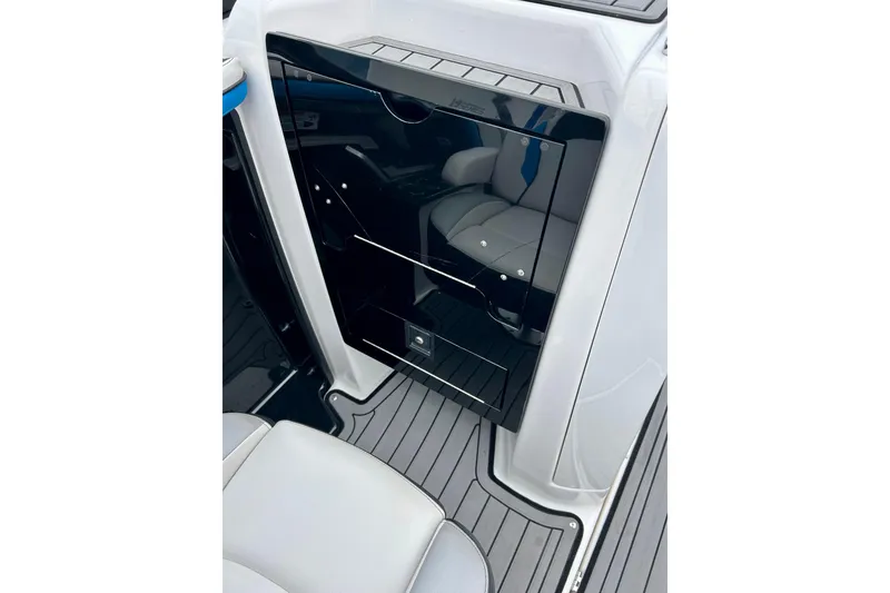 Slide: The Image of 2018 Yamaha Boats 242X interior with sleek black storage compartment and gray seating. - 44