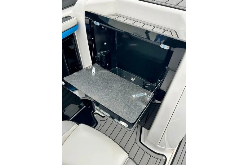 Slide: The Image of 2018 Yamaha Boats 242X interior storage compartment with open hatch and sleek design. - 45